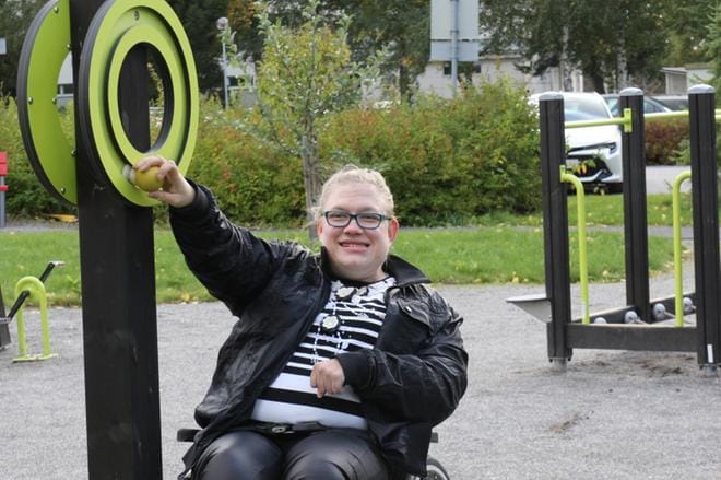 Jenni Louhivesi testaa esteettömän puiston toiminnallisia ulkoliikuntavälineitä. KUVAT: MARIA KYLMÄLUOMA