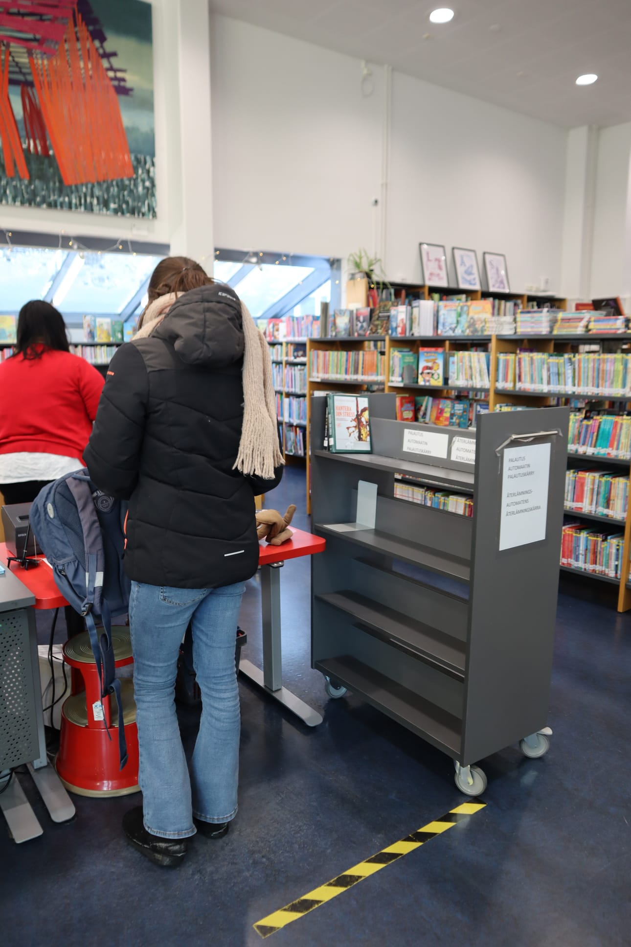 Kirjojen omatoiminen palautus toimii Sundomissa samalla laitteella kuin lainaus. Palautuksen jälkeen kirja laitetaan palautushyllyyn.