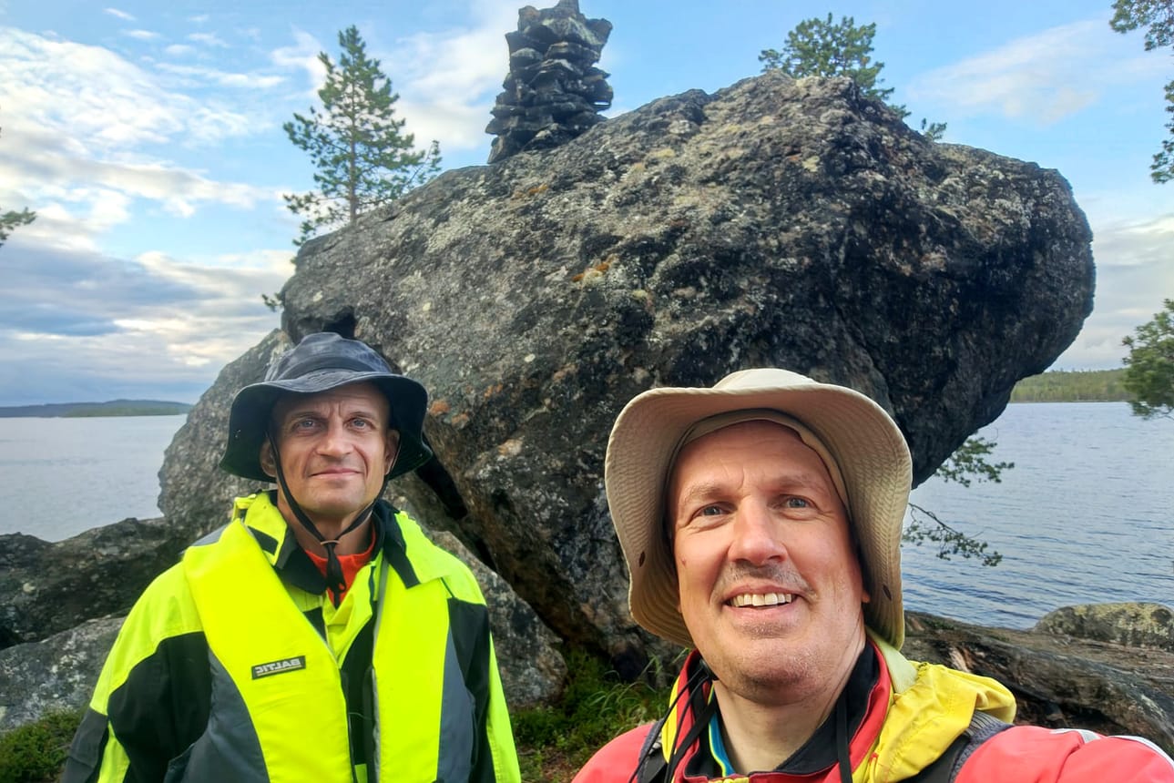 Henri Korhonen (oik.) ja Tiera Laitinen Täyssinän rauhan rajapyykillä Kaamassaaressa Inarijärvellä. Kaamassaari oli Korhosen viimeinen melontakohde Suomen sadan suurimman saaren listalla.