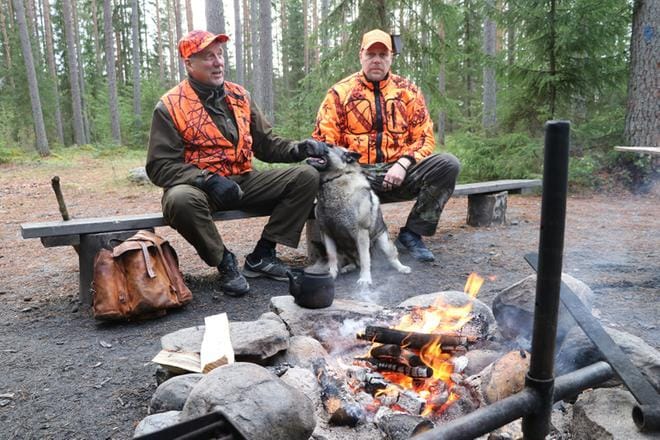 Metsälaavulla hirvimiehet Erkki ja Ari Hautakangas sekä norjanharmaahirvikoira Nemo. KUVA: SAILA COLLANDER