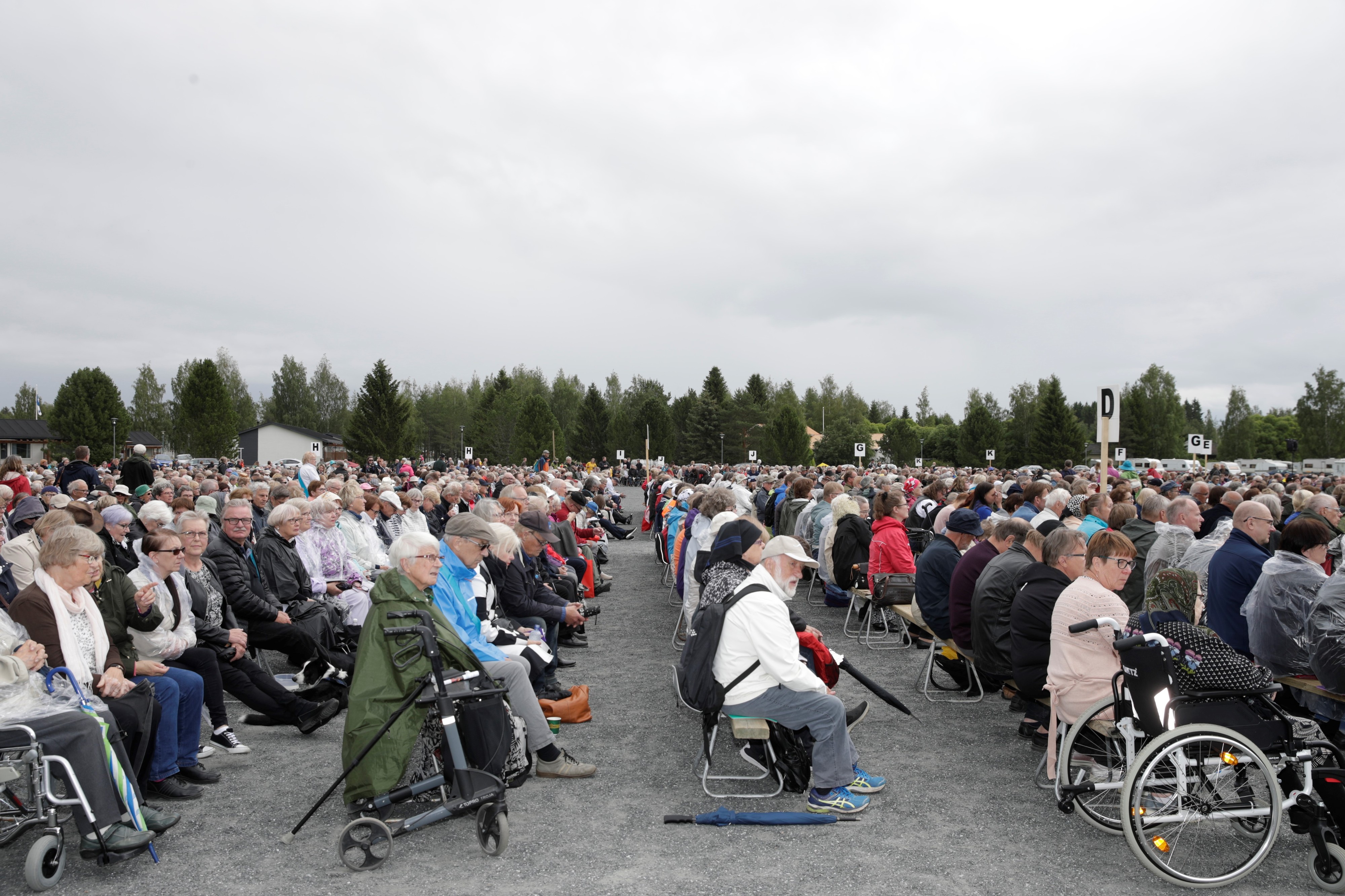 Herättäjäjuhlien yleisö istuu puisilla penkeillä. Viikonvaihteen aikana juhlilla käy arviolta 25 000 ihmistä.