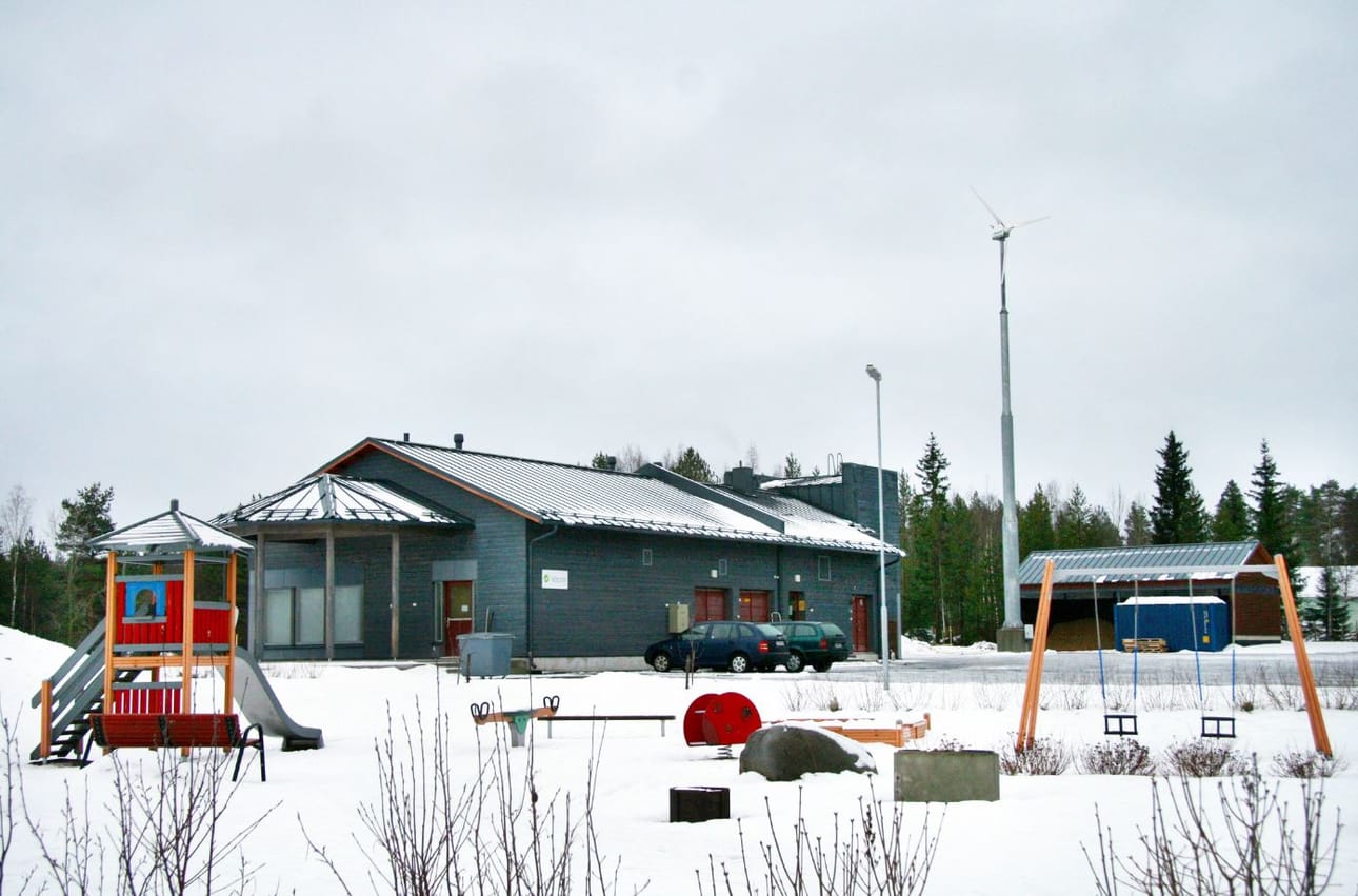 Asuinalueen voimalassa tuotetaan sähköä tuulella ja puuhakkeella.