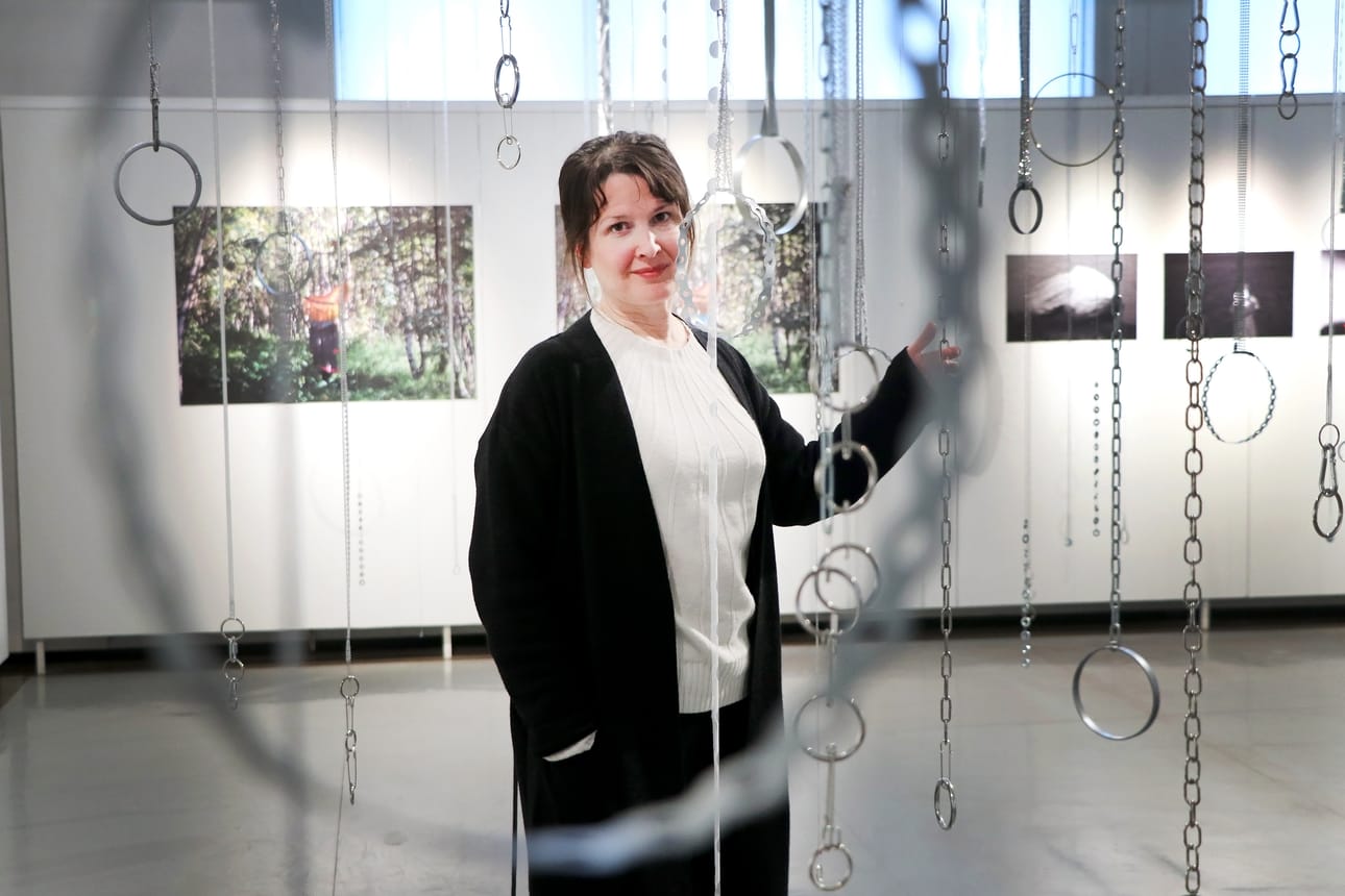 Amanuenssi Soile Haapala kertoo, että metalli ja muut kovat materiaalit ovat helpompia puhdistaa näyttelyn jälkeen kuin esimerkiksi huokoiset paperi ja kangas. Alku-utopiat -näyttelyssä metalliosia sisältävän installaation on tehnyt Jenni Laiti. Valokuvat taustalla ovat Lada Suomenrinteen.
