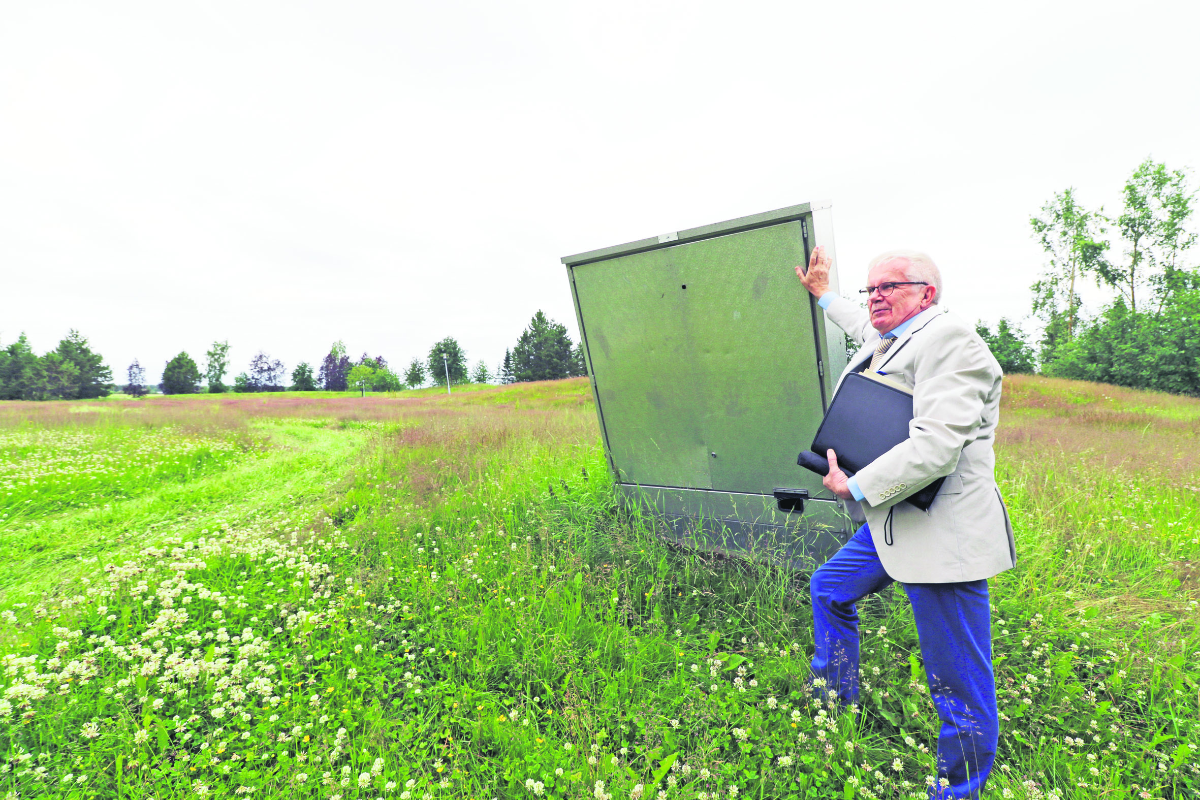 Veikko Hätälä nojailee opetuspuutarhan sähkökaappiin. Taustalle olevalle alueelle suunniteltiin aikoinaan esiintymisareenaa, mutta se päätettiin rakentaa lopulta muualle. Oppilaitoksen entinen rehtori toivoisi puutarhalle uutta tulevaisuutta.