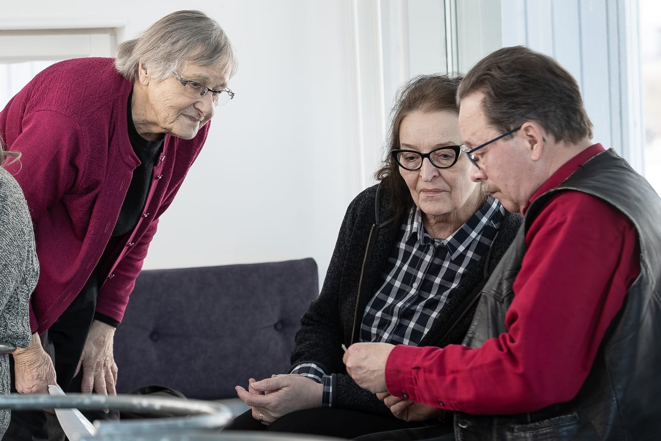 Taimi Kuorilehto esittelee vanhoja kuvia Matista Pirkko Hilakivelle ja Kauko Äijälälle.