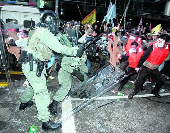 Tätä mieltä. Hong Kongin mellakkapoliisit ottivat yhteen WTO:n kokousta vastaan protestoivien eteläkorealaisten maanviljelijöiden kanssa.