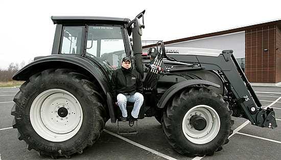 Traktorimyyjä Topi Väänänen istuu Valtran isoimman Oulussa myytävän traktorin rappusilla. Tehoa laitteessa on noin 200 hevosvoimaa ja hinta on noin 145 000 euroa. Näitä laitteita käytetään esimerkiksi turvesoilla ja suurimmilla tiloilla.