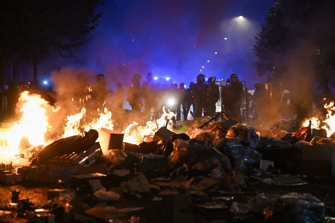 Poliisit seisoivat palavan tavarakasan lähellä Place de la Républiquen edustalla lauantai-iltana.