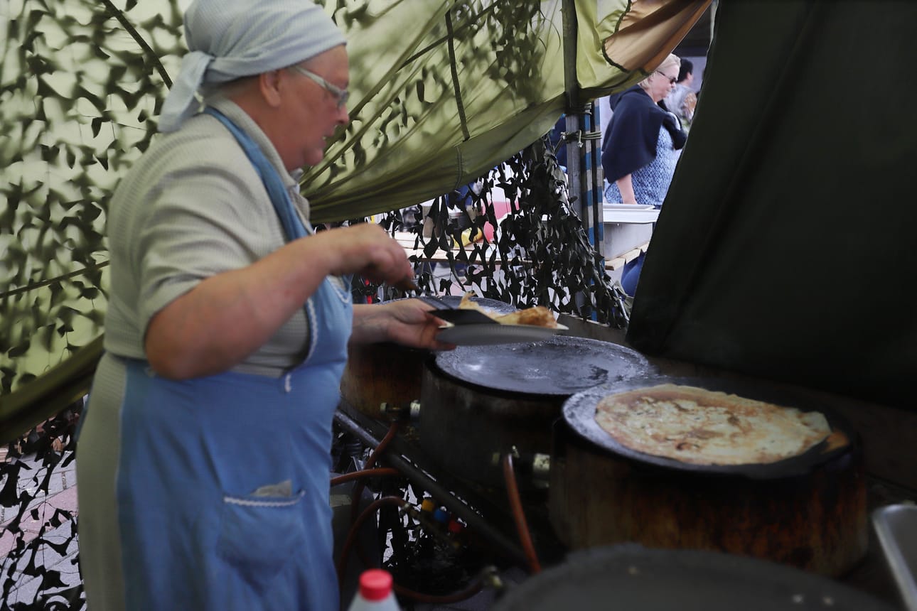 Kainuun sotilaspiirin perinneyhdistyksen, Leena Sainio paistoi lättyjä satoja kappaleita Raahen Pimiöiden vieraille.