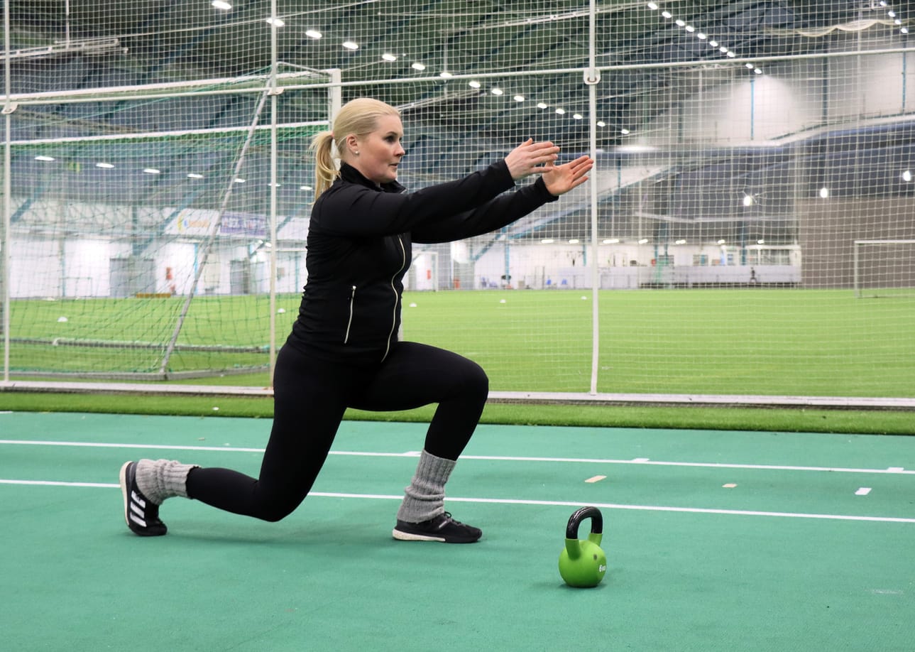Personal trainer Lena Paxal näyttää jalkakyykyn mallia. Liikkeen voi tehdä ilman käsipainoja tai käsipainojen kanssa. Myös kahvakuula käy.