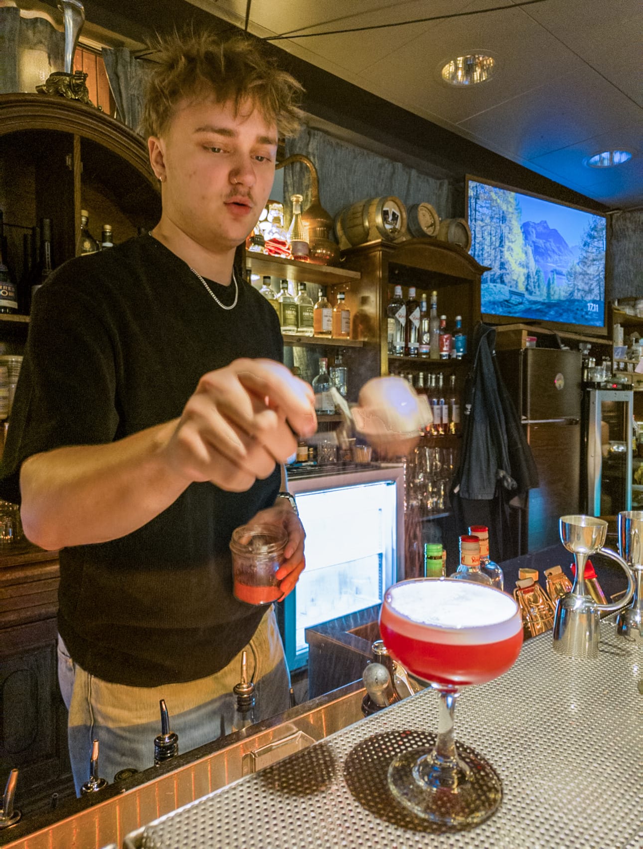 Baarimestari Miro Virta koristelee mocktailin puolukkajauheella.