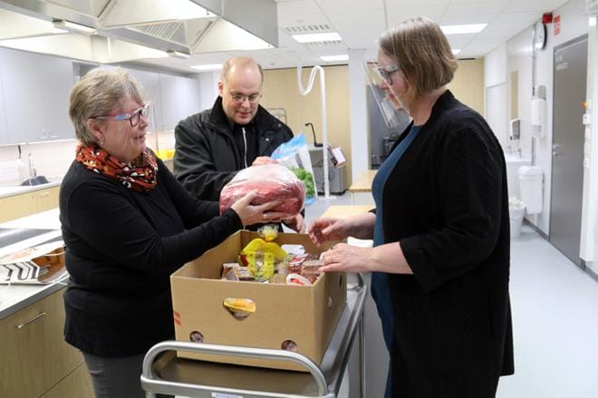Kaija Aro ja Seppo Rintakumpu ojensivat kotitalousopettaja Jaana Kontkaselle laatikollisen kotimaisia raaka-aineita yläkoulun oppilaita varten. KUVA: ANU NAHKALA