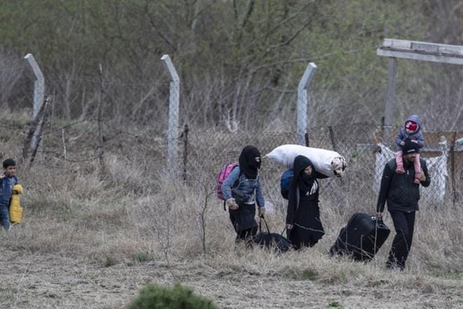 Pakolaisperhe käveli Edirnen kaupungin lähettyvillä Turkissa pyrkien kohti Kreikan rajaa 10. maaliskuuta. Kuva: EPA