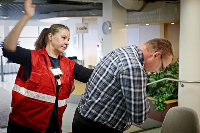 Suomen Punaisen Ristin Ensiapukoulutus Oy:n freelancer ETK-kouluttaja Kati Kujala ja Ari Kujala näyttävät, miten vierasesineeseen tai ruokaan tukehtuvalle annetaan ensiapua. Avuanto aloitetaan lyömällä kämmenellä lapaluiden väliin. Lyönti toistetaan tarvittaessa viisi kertaa. KUVAT: KARI LÖFHJELM