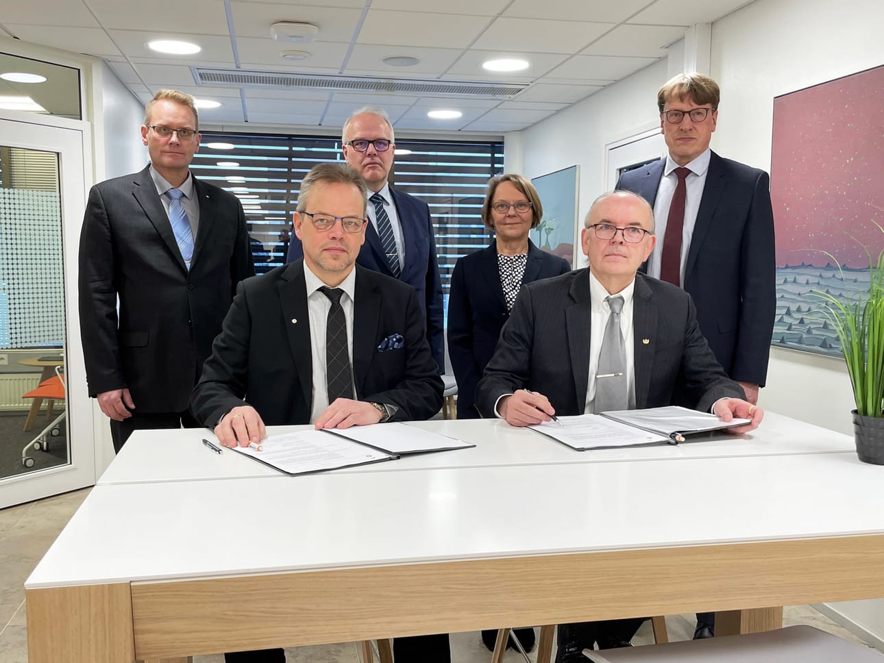 OP Peräseinäjoen hallituksen puheenjohtaja Jaakko Korkonen ja OP Alavuden hallituksen puheenjohtaja Erkki Holkko allekirjoittivat yhdistymissuunnitelmat. Takana vasemmalta lukien toimitusjohtaja Juha Mäki, hallintoneuvoston puheenjohtajat Petri Ollinkoski ja Päivi Kujala sekä toimitusjohtaja Jussi Ruuhela.
