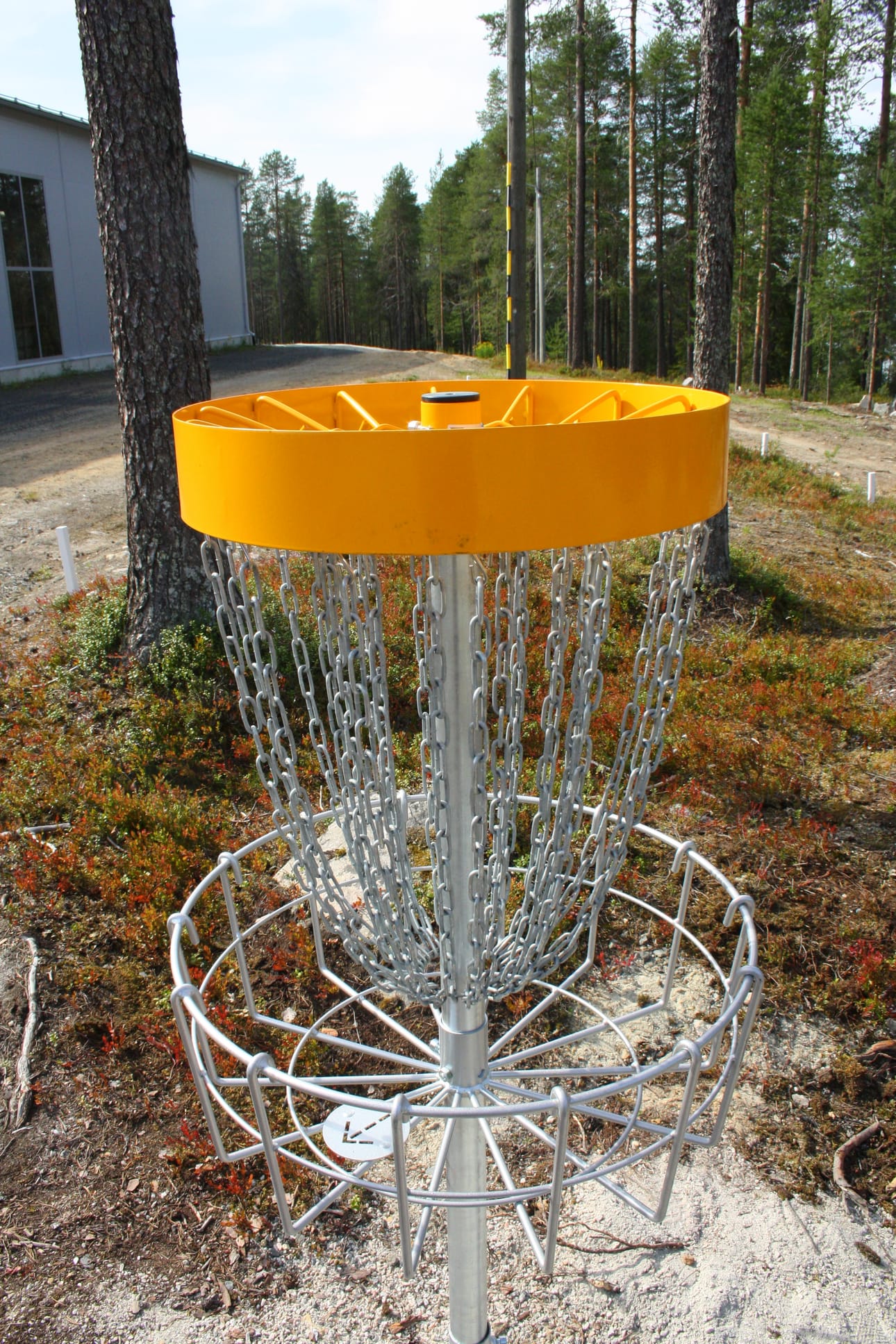Posion Korkeamaan frisbeegolfradan viimeisen eli 12. väylän kori on Sini-areenan eli monitoimihallin (vas.) takana. Kuvan keskilinjalla mäen taitteen takana on yhdeksännen väylän kori.