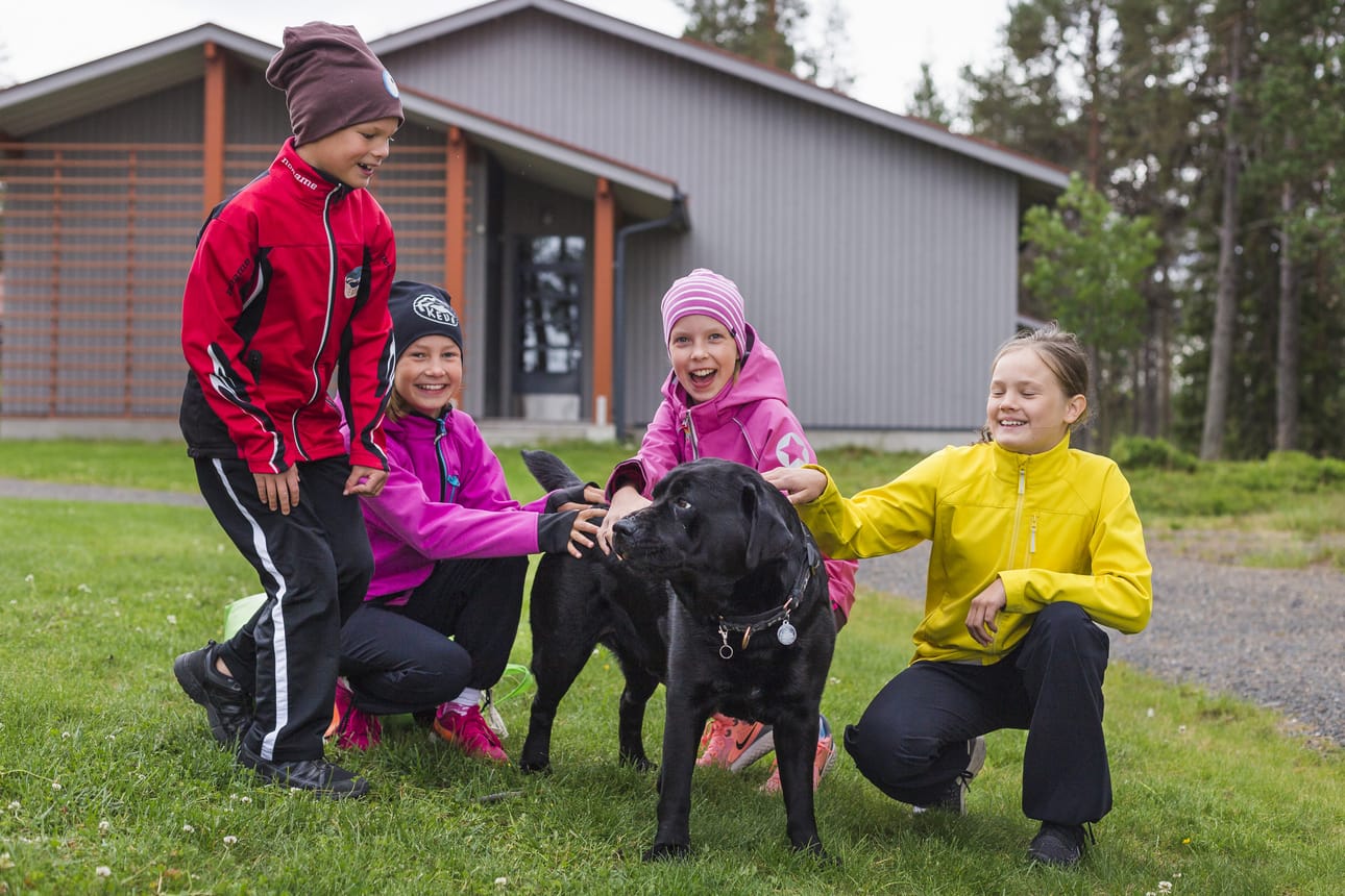 Antti-Pentti, Marina ja Petriina Määttä sekä Ea Kallunki viihtyvät Purjehduskoulussa. He ovat kaikki purjehtineet jo kolmen kesän ajan. Riitta Laulajaisen Sauli-koiran rapsutteleminen on myös hauska osa kerhohetkiä.