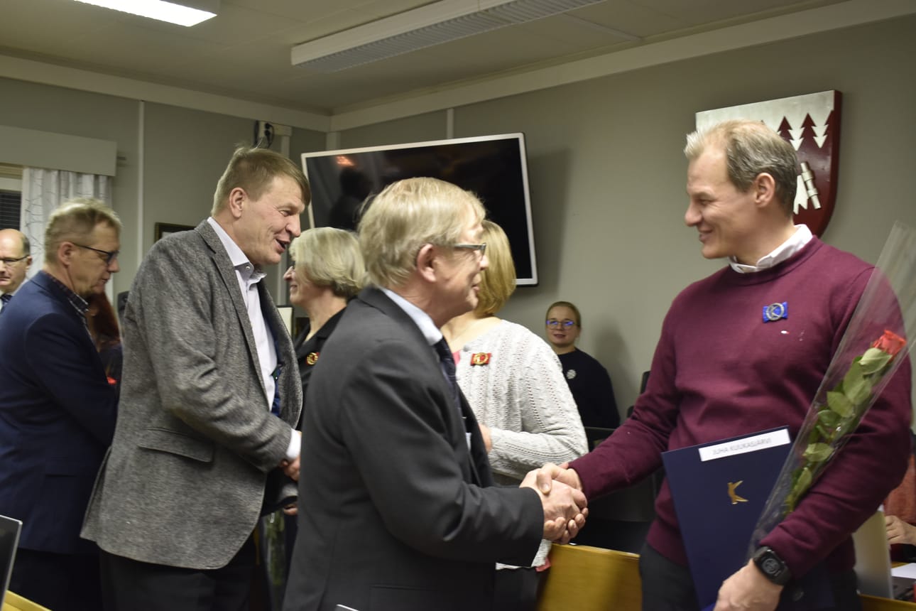 Kokouksessa jaettiin Kuntaliiton ansiomerkkejä. Kuvassa Niilo Keränen onnittelee Juha Kuukasjärveä, joka sai hopeisen ansiomerkin 20 vuoden luottamustehtävistään Taivalkoskella.