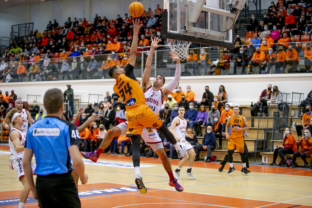 Karhu Basketin Lee Skinner heittää, Bisonsin Zach Thomas puolustaa.