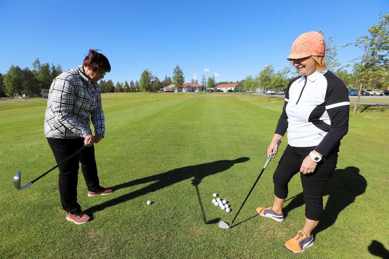 Kymmenen vuotta golfannut Heli Juusola opastaa Hilkka Katajamäkeä oikean lyöntitekniikan löytymisessä.