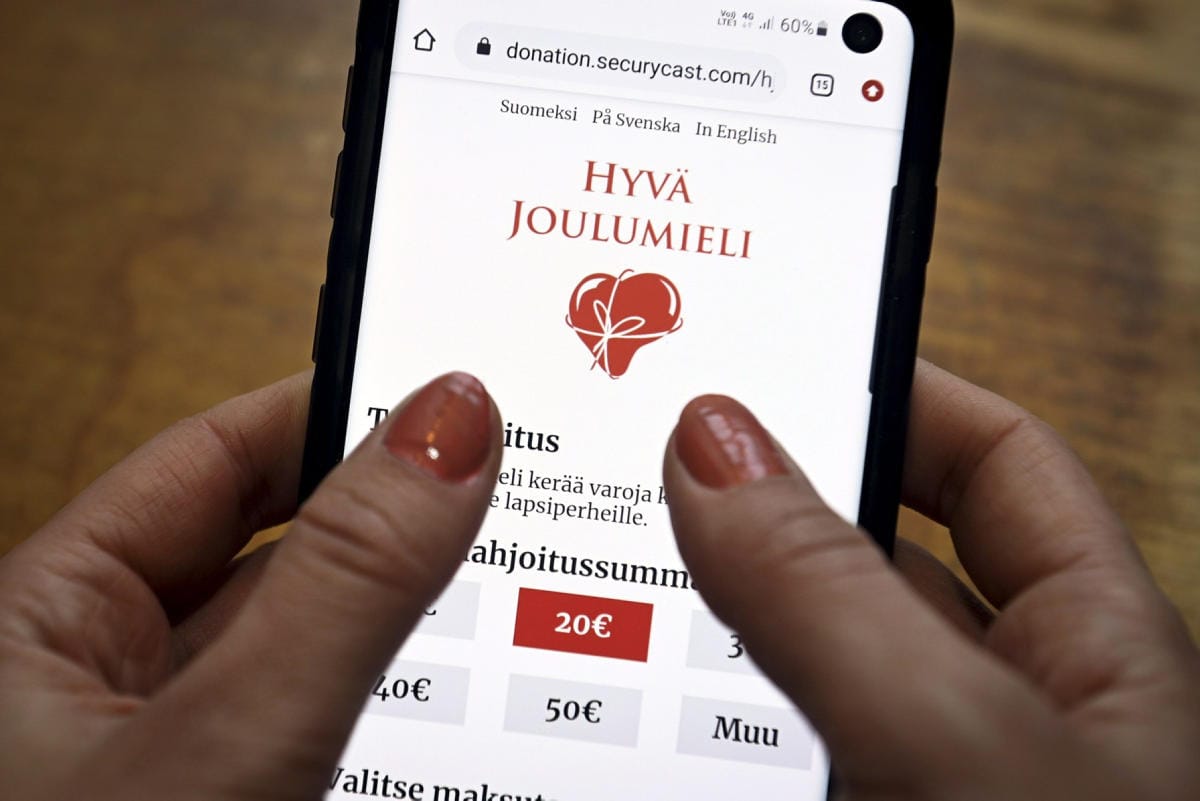 Nainen katseli Hyvä Joulumieli -keräyksen sivuja puhelimellaan viime vuoden marraskuussa. LEHTIKUVA / EMMI KORHONEN
