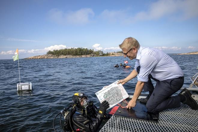 Ministeri Kimmo Tiilikainen vihki Porkkalan hylkypuiston Porkkalanniemen edustalla maanantaina. Hylkypuiston projektipäällikkö Markku Luoto lähti viemään puiston opastekylttiä kymmenen metrin syvyyteen.