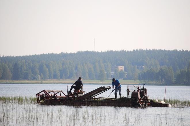 Juhani Riiho ajaa rakentamaansa niittokonetta. Timo Rintala toimii apumiehenä. KUVA:EEVA-LIISA KULJU