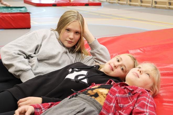 Maini Haapamäki, Sara Korpela ja Sini Kiviniemi heittivät pitkäkseen liikuntasalin paksulle patjalle. KUVAT: EEVA-LIISA KULJU