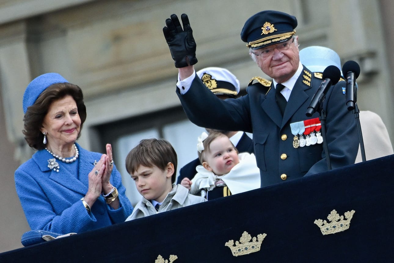 Ruotsin kuningas Kaarle XVI Kustaa ja kuningatar Silvia tervehtivät yleisöä kuninkaan syntymäpäivänä. Kuvassa myös Prinssi Carl Philipin sylissä prinsessa Ines ja edessä prinssi Gabriel.