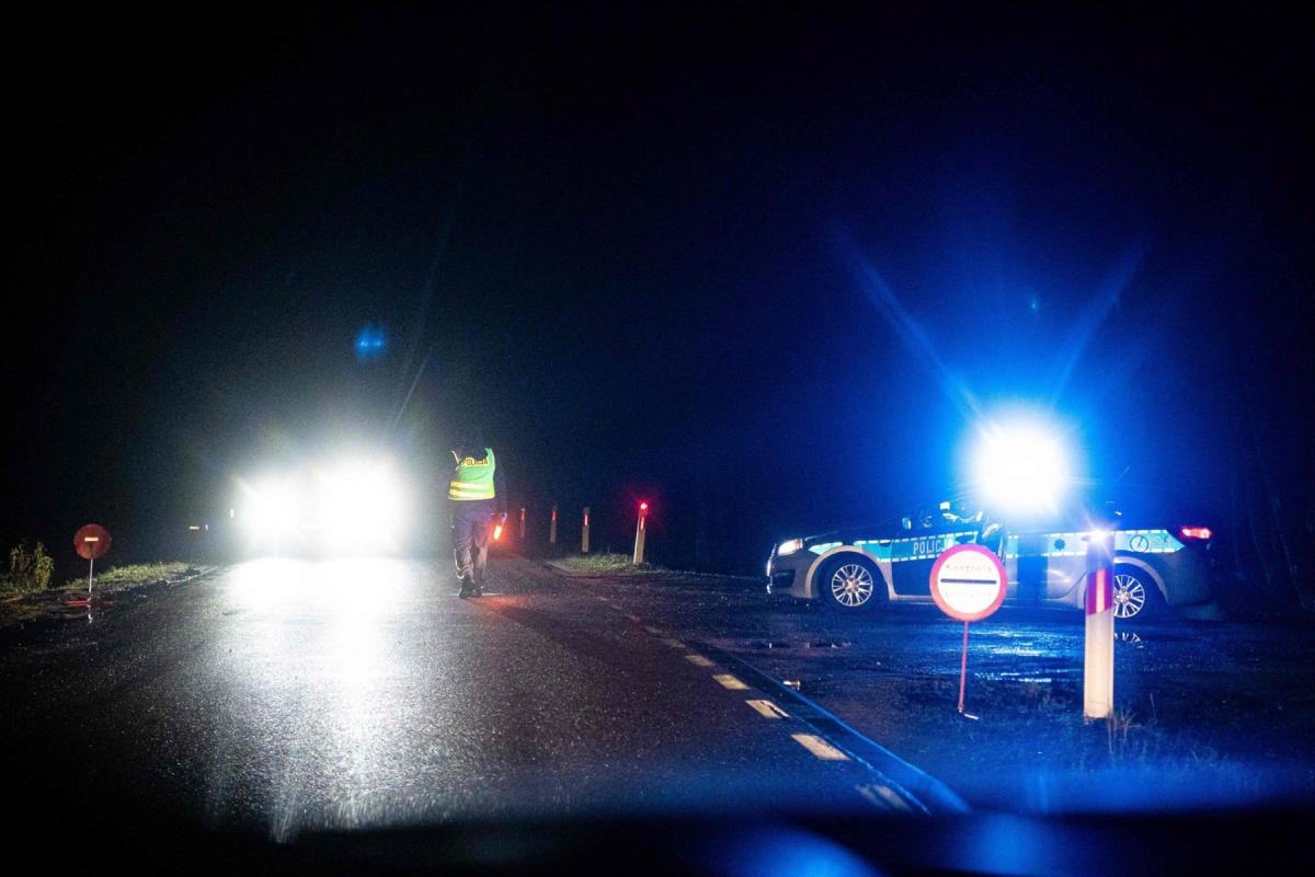 Poliisi tarkastaa autoja tarkastuspisteellä lähellä Bialowiezan kylää Puolassa. Kuva otettu 21. marraskuuta. LEHTIKUVA/AFP