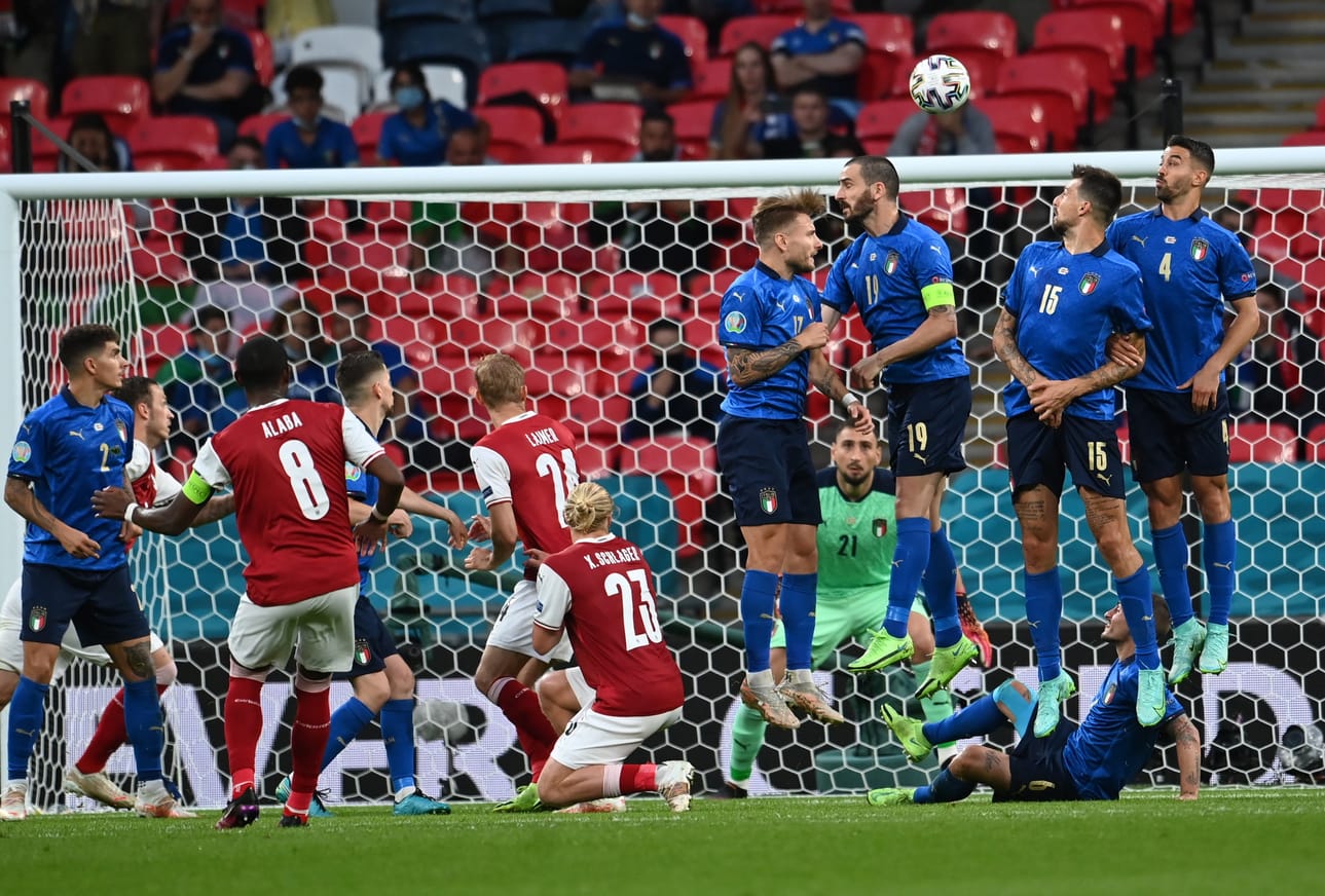 Italian maalivahti Gianluigi Donnarumma valmistautuu torjumaan Itävallan David Alaban vapaapotkua.