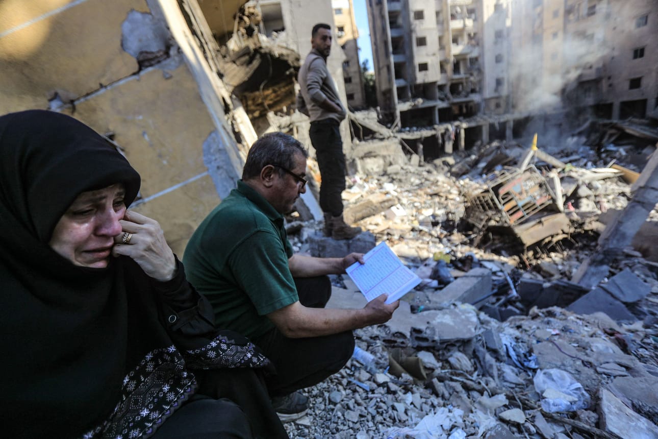 Nainen itkee ja mies lukee Koraania Israelin ilmaiskuissa romahtaneen rakennuksen edessä Libanonin pääkaupungin Beirutin eteläisessä lähiössä. Hizbollahin johtaja Hassan Nasrallah tapettiin iskuilla. LEHTIKUVA/AFP