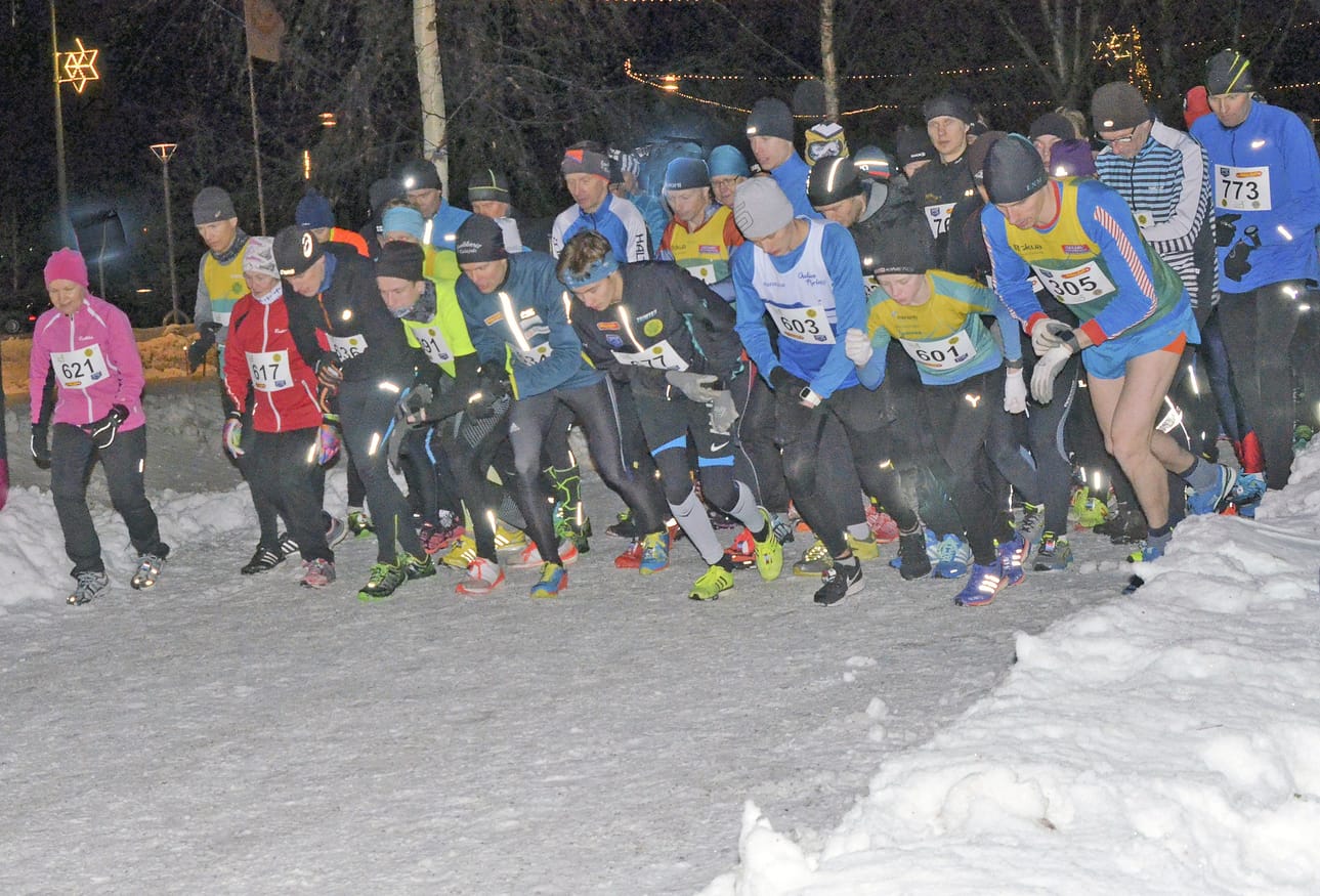 Juoksijat valmiina lähtöön. Uudenvuodenjuoksussa jalka nousi rakettien valaistessa taivasta.