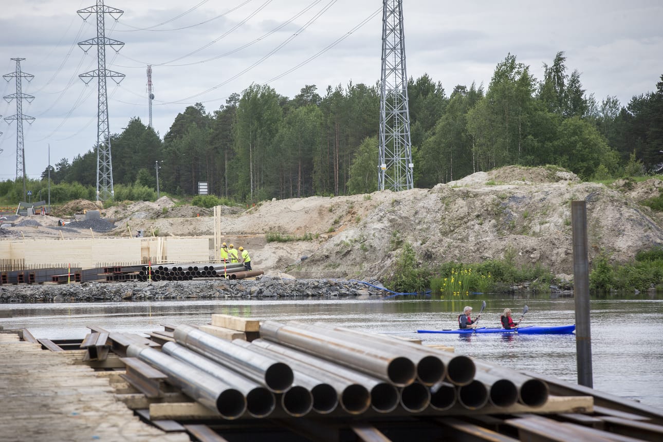 Joen pohjoisrannalla työsillan rakennus on jo hyvässä vauhdissa. Toinen työsilta rakennetaan etelärannalta ja väliin jätetään kymmenen metriä leveä väylä veneitä varten.