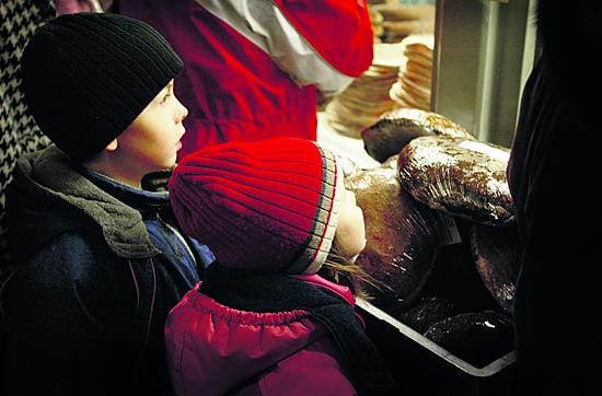 Tiskeille täydennystä. Jouluaaton aatto yksi Kauppahallin vilkkaimmista myyntipäivistä piti myymälöiden henkilökunnan kiireisinä koko päivän. (Kuva epäselvästä hahmosta keskellä