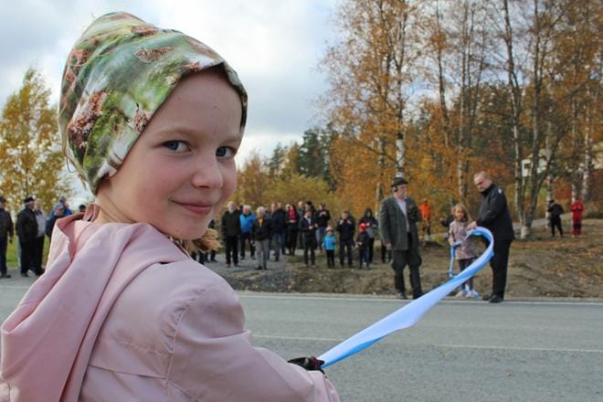 Iida Peurala ja Sanni Takala (taustalla) pitivät sinivalkoista nauhaa, kun Alavuden Kätkänjoella juhlistettiin tienkorjauksen ja päällystyksen valmistumista lokakuussa 2021. ARKISTOKUVA: REIJO HEIKKILÄ