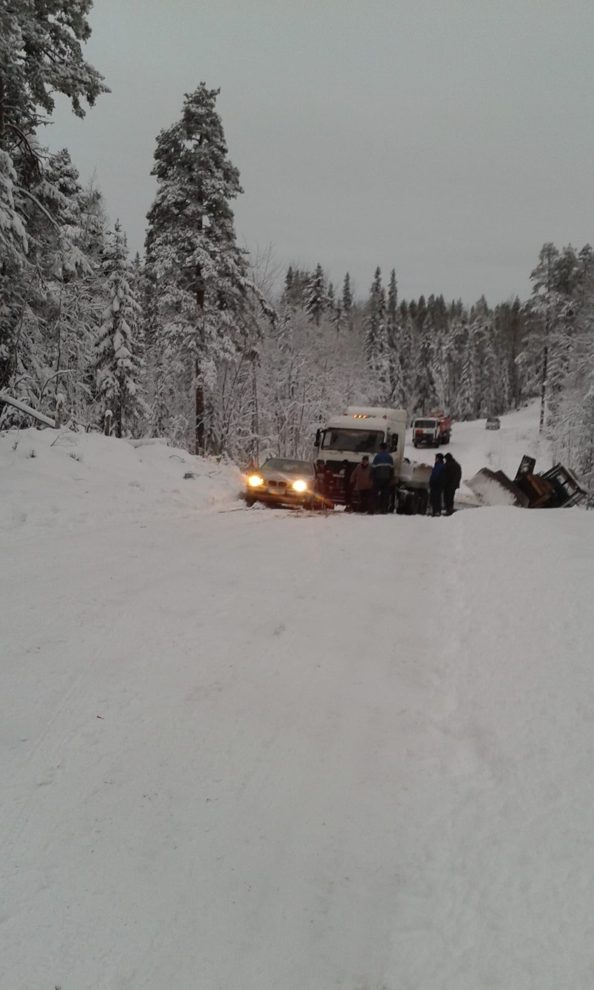 Auto juuri ohittamassa onnettomuusrekan keulaa. Lapiomiehet olivat saaneet ohituskaistan juuri ja juuri ajettavaksi. Ilman nastoja ei siitä olisi ollut yrittämistä.