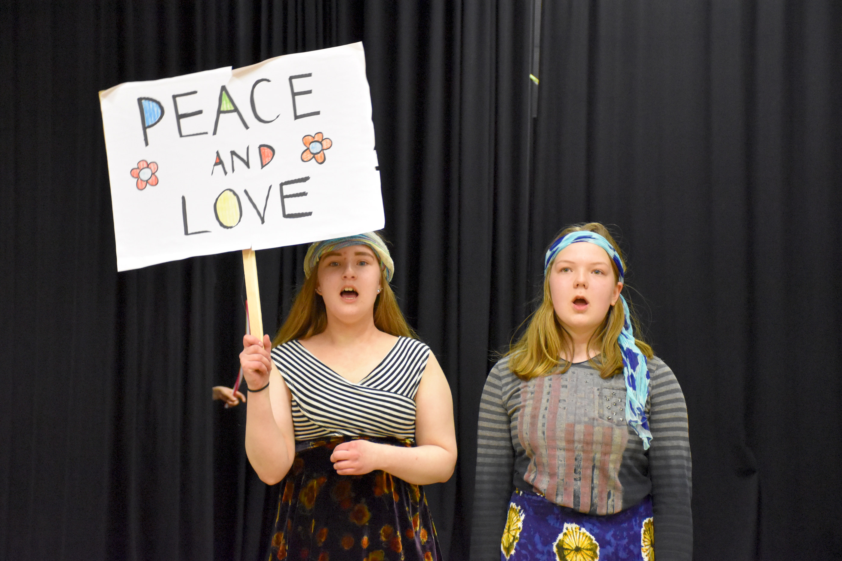 Posion nuorten Hömppä -teatterin Aikamoinen aikamatka -näytelmä vie nuoret eri vuosikymmenille. Peace and love -kylttiä kantava Anni Suonnansalo marssii yhdessä Petra Määtän kanssa rauhan ja rakkauden puolesta.