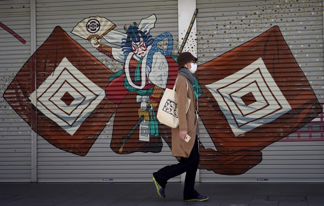 Nainen käveli Tokion Asakusassa suljettujen kauppojen editse tiistaina. Turistien suosima alue on koronaviruksen tyhjentämä.