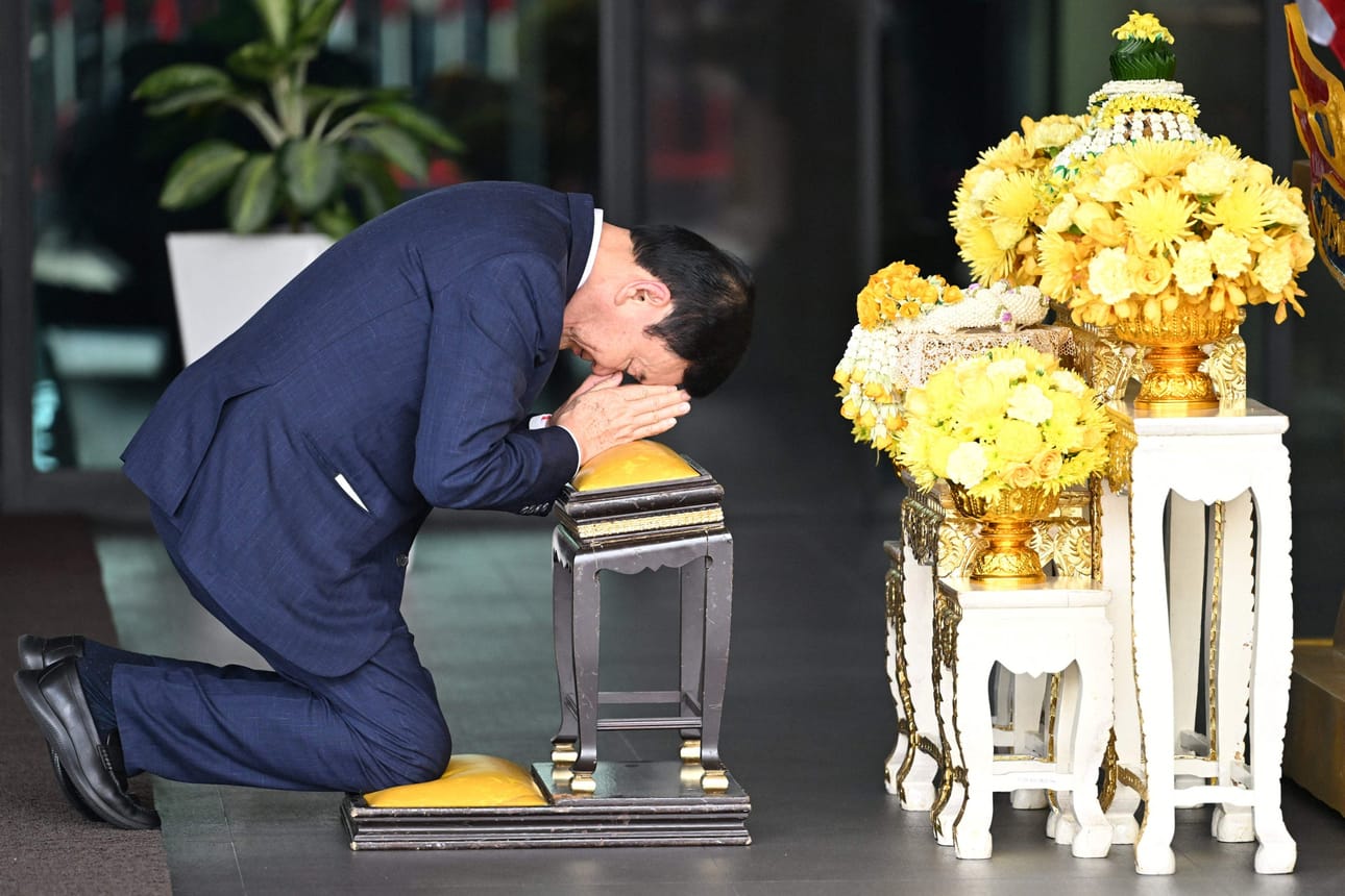 Thaimaan entinen pääministeri Thaksin Shinawatra kumarsi Bangkokin lentokentällä kuninkaan kuvalle palattuaan maanpaosta kotimaahansa. LEHTIKUVA/AFP