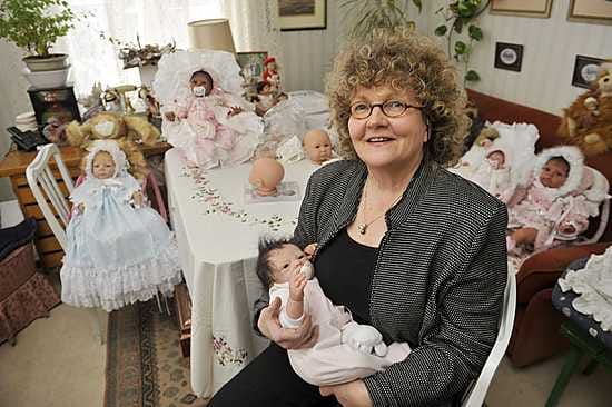 Nukentekijä Eija Okadigbo-Salonen sylissään Reborn baby -vauvanukke.
