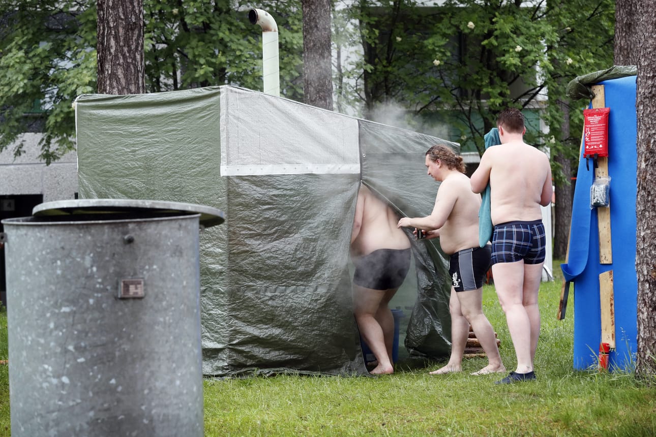 Saunojia Intiön vesitornin viereen pystyllä telttasaunalla.