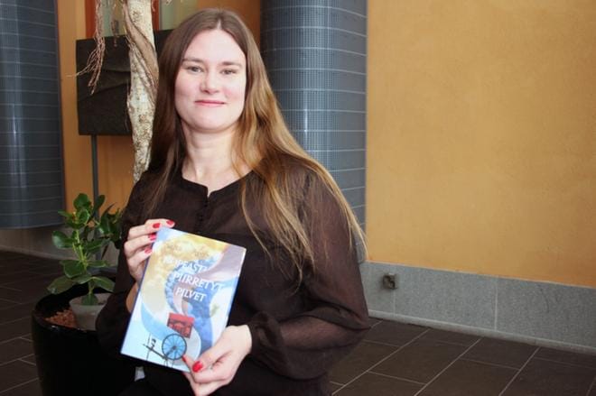 Paula Nivukoski pitelee käsissään tuoretta esikoisteostaan Nopeasti piirretyt pilvet, jonka tarina pyörii hänen juurillaan Isossakyrössä. Nivukosken ajatukset liikkuvat jo uuden, työn alla olevan teoksen parissa. Tarina ajoittuu niin ikään 1920-luvun Pohjanmaalle. Kuva: Katja Lahti