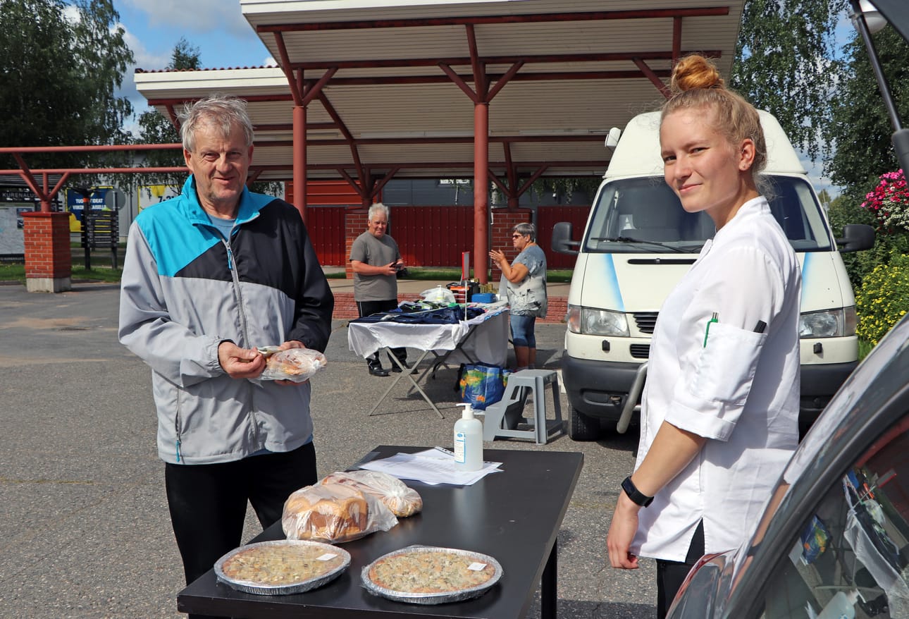 Henna Tolonen möi kahvileipää Pudasjärven torilla. Pentti Ollila valitsi Tolosen leipoman pullapitkon.