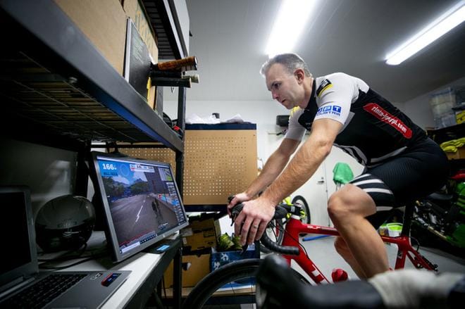 Juha Tuuri tarkkailee näytön ruudulta sykettään ja tehojaan polkiessaan maantiepyörällään virtuaalisesti kotinsa varastotiloissa. KUVAT: JAAKKO ELENIUS