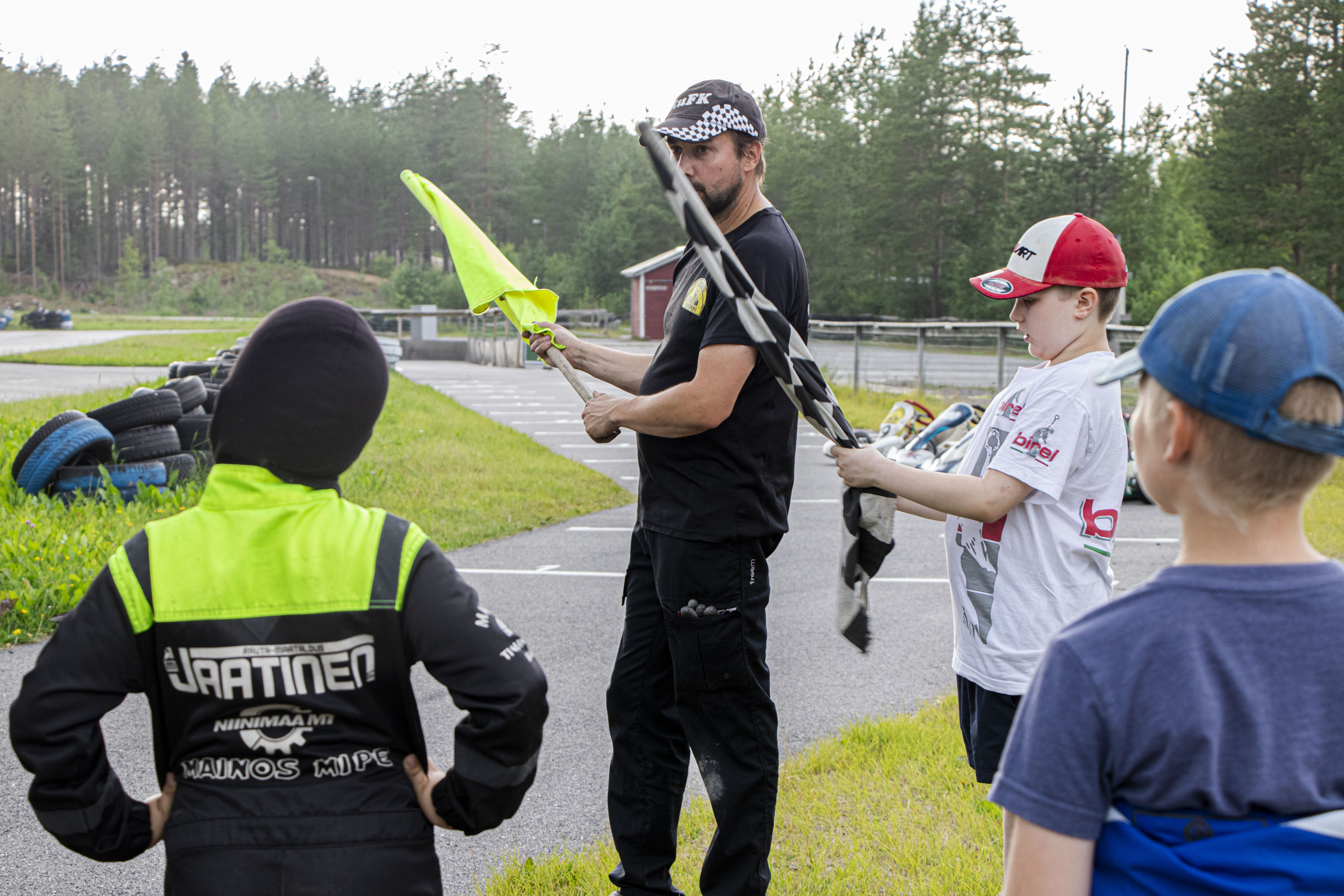 Reni ja Eepi Mäki-Uuro kertovat karting-koululaisille  ihan ensimmäisenä, mitä eri väriset liput tarkoittavat. 