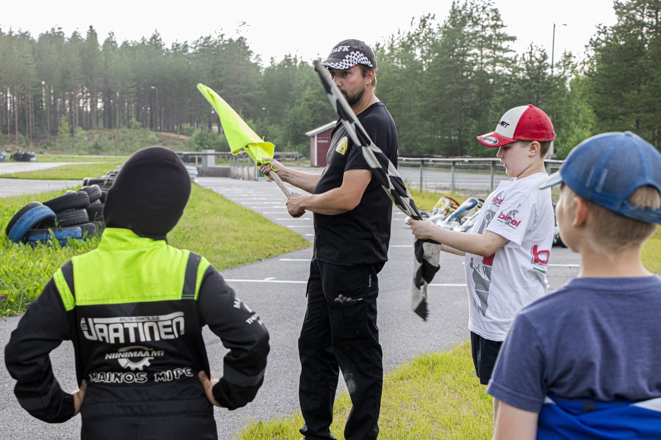 Reni ja Eepi Mäki-Uuro kertovat karting-koululaisille ihan ensimmäisenä, mitä eri väriset liput tarkoittavat.