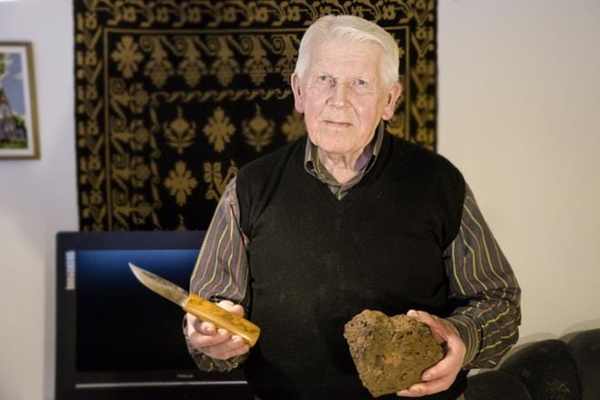 Yrjö Puronvarsi pitelee puukkoa, jonka kaikki vaiheet karkaisua myöden hän on tehnyt omin käsin. Jopa puukon terään tarvitun takoraudan hän on polttanut rautamalmista itse. KUVA: JUHA AHO-PYNTTÄRI