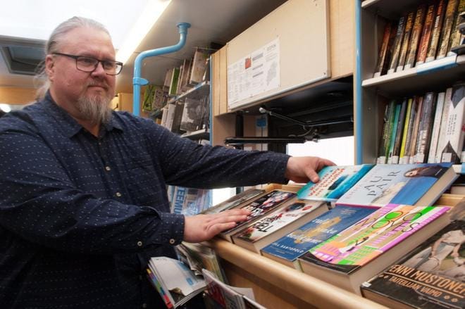 Uutuuskirjat ovat kirjastoautossa omassa hyllyssään. Marko Tusa kertoo lukeneensa nuorena paljonkin ja arvelee lukuinnostuksen uuden työn ansiosta taas elpyvän. KUVA: KAROLIINA SYRJÄ