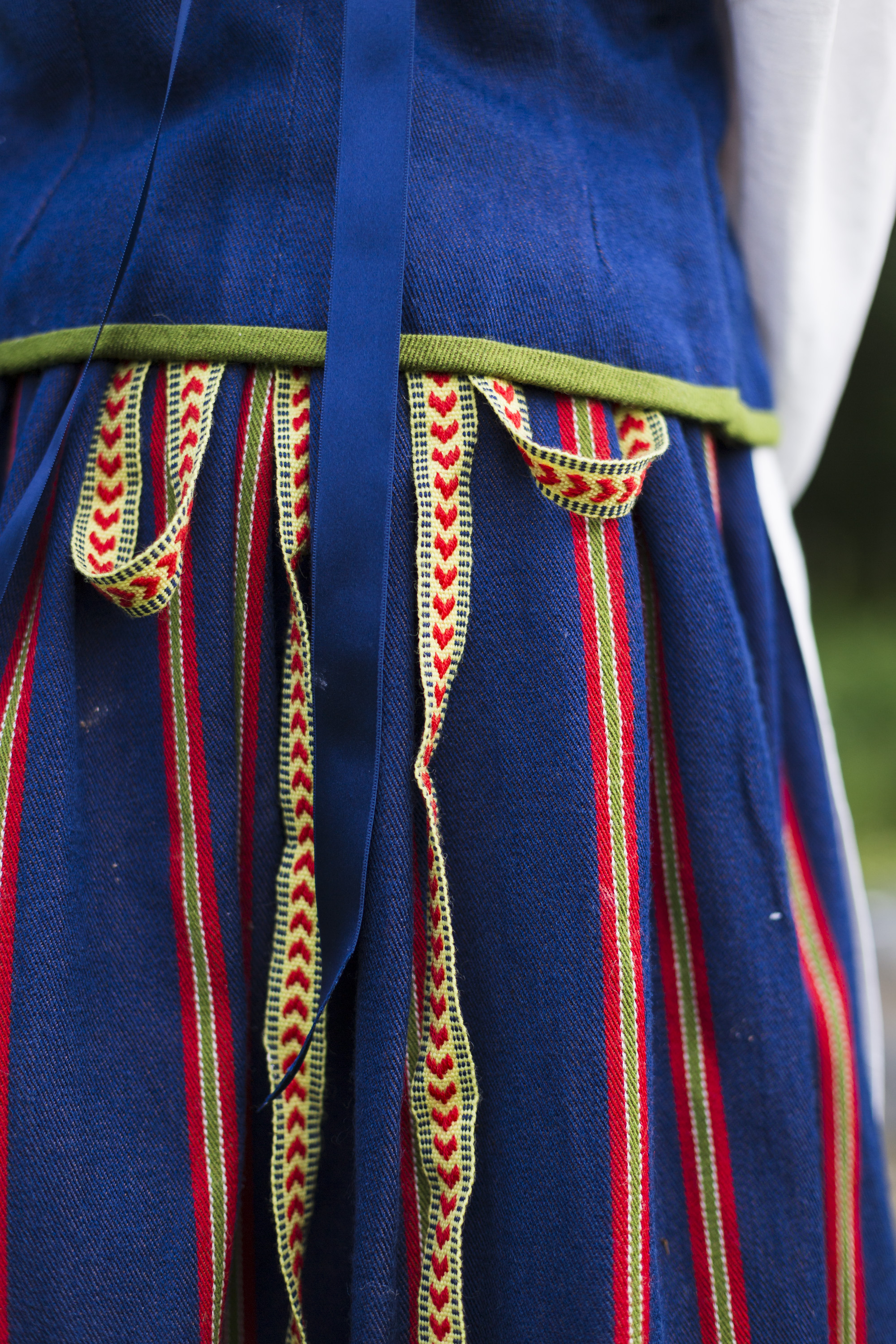 Koillismaan kansallispuvussa hehkuvat punainen, keltainen ja vihreä syvää sinistä vasten. Pirtanauhan kuviota kutsutaan lohenpyrstökuvioksi.